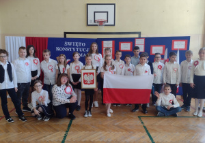 Grupa dzieci ubrana na galowo trzymającą flagę Polski